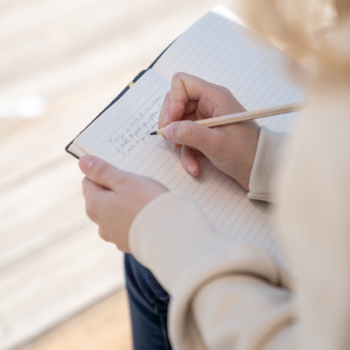 Woman is writing something on a piece of paper