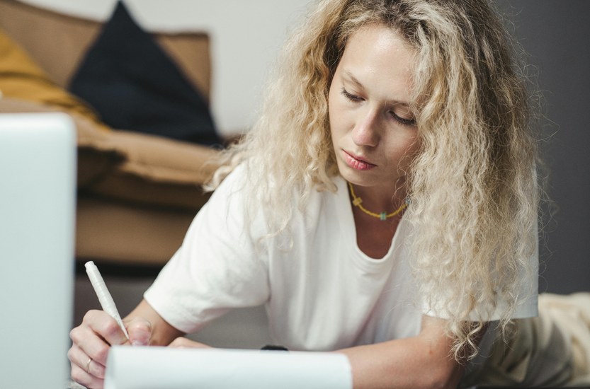 Person sitting at a table with a notebook planning a quit schedule, gradual tapering concept