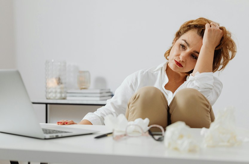 Woman sitting in a quiet kitchen at night with a cup of tea, looking thoughtful and at ease
