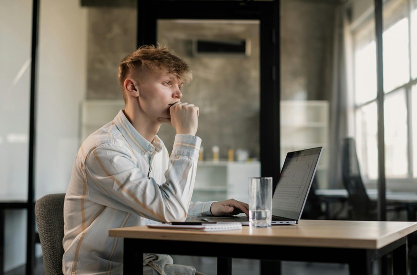 Man at desk with laptop working, reflecting on a lost year of weed use