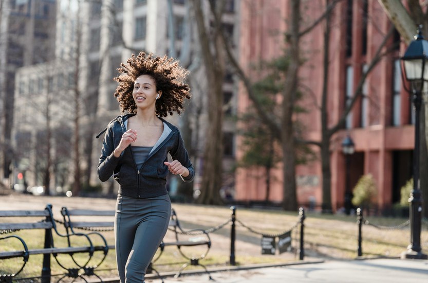 Woman walking on city sidewalk, healthy lifestyle after quitting weed