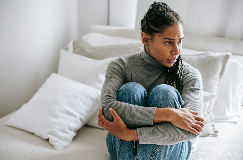 Person sitting on edge of bed at night looking anxious and restless after quitting weed