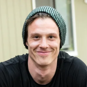 Smiling young man wearing a green knit beanie