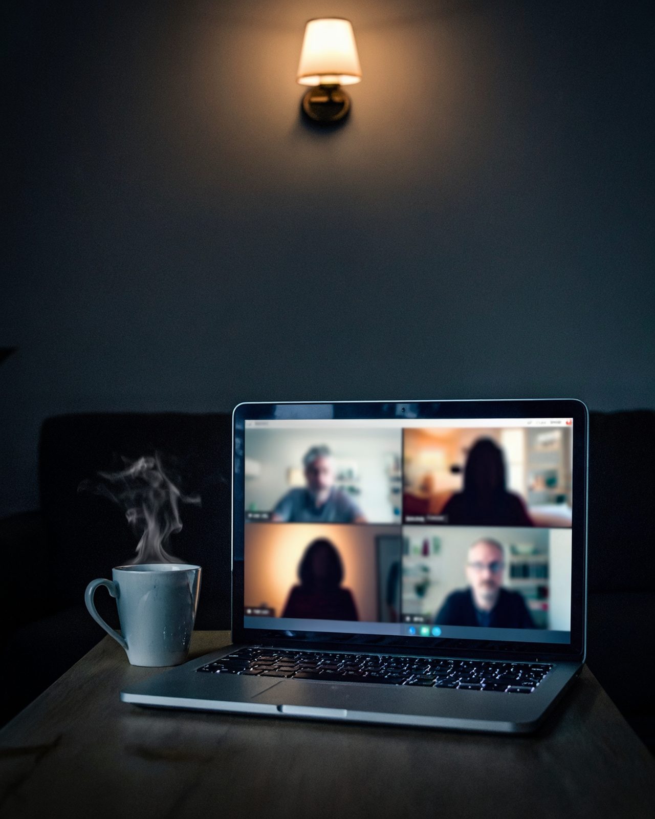 Laptop showing a video call in a dark living room