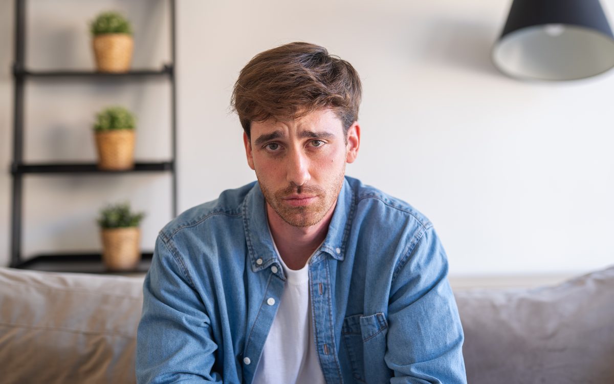 Young man sitting thoughtfully on the sofa